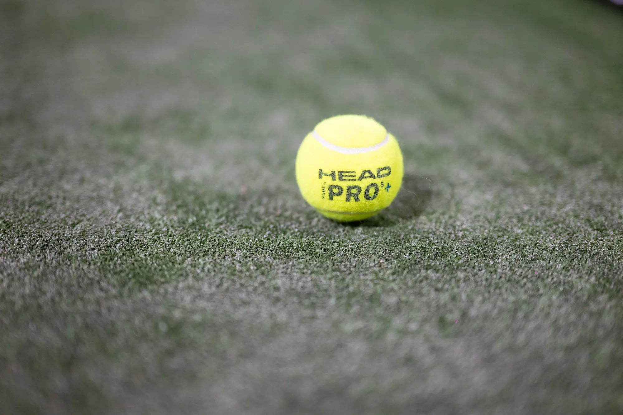 Yellow HEAD Pro ball on green artificial turf