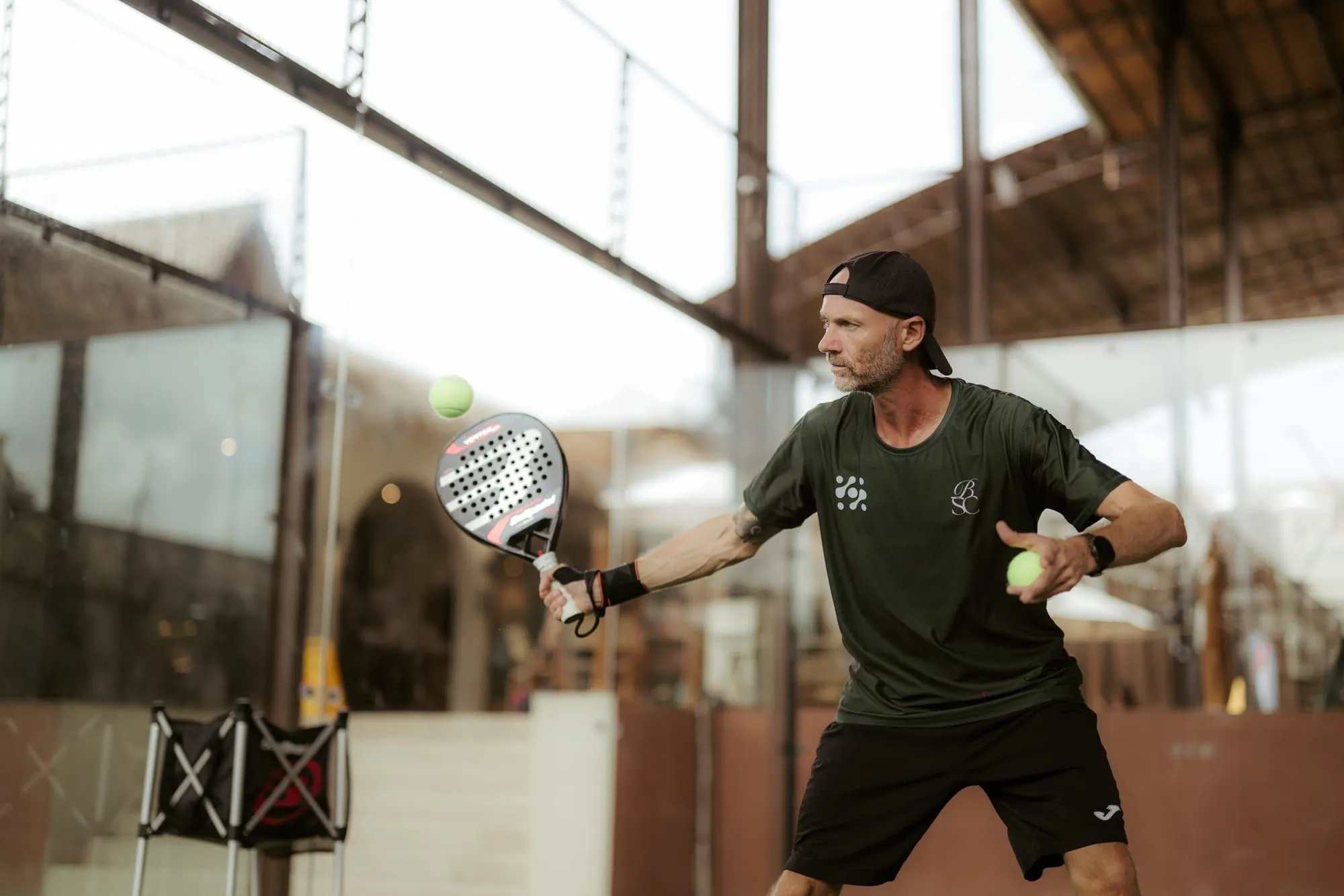 Padel player preparing to hit a ball on court
