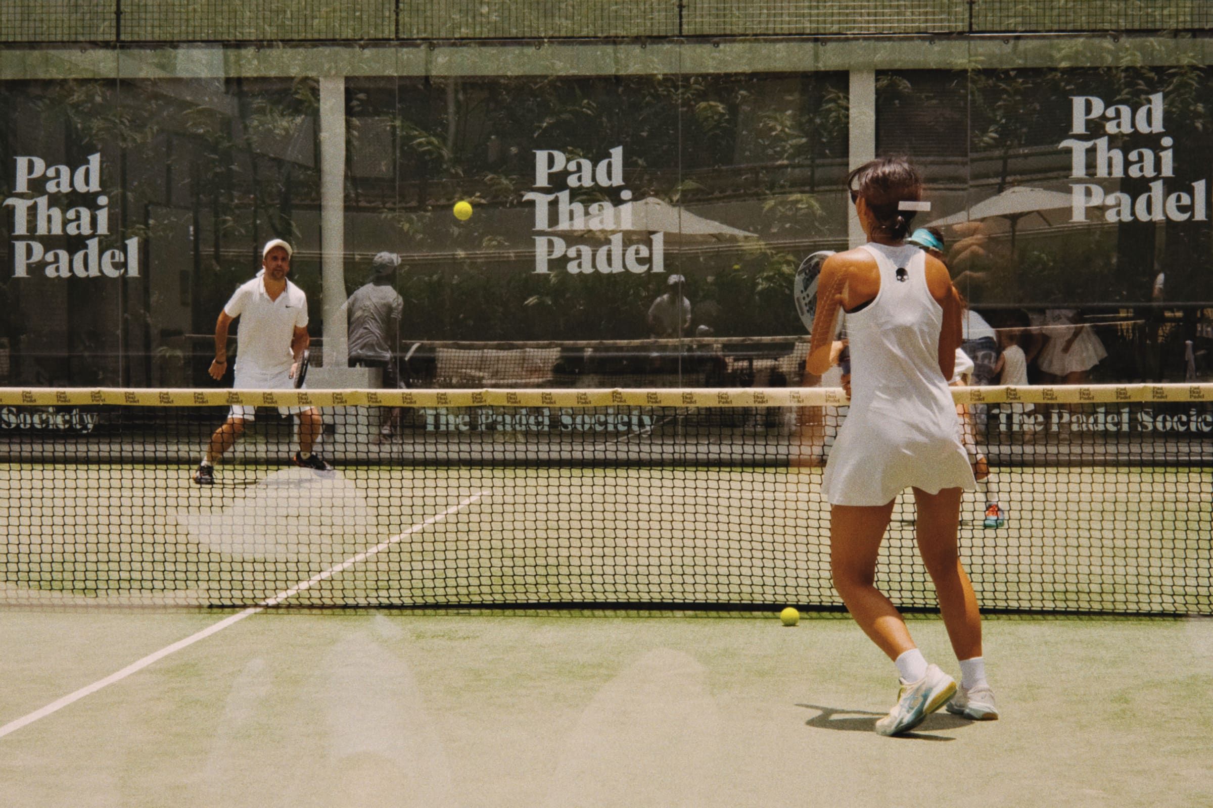 Padel players on an outdoor court in Thailand