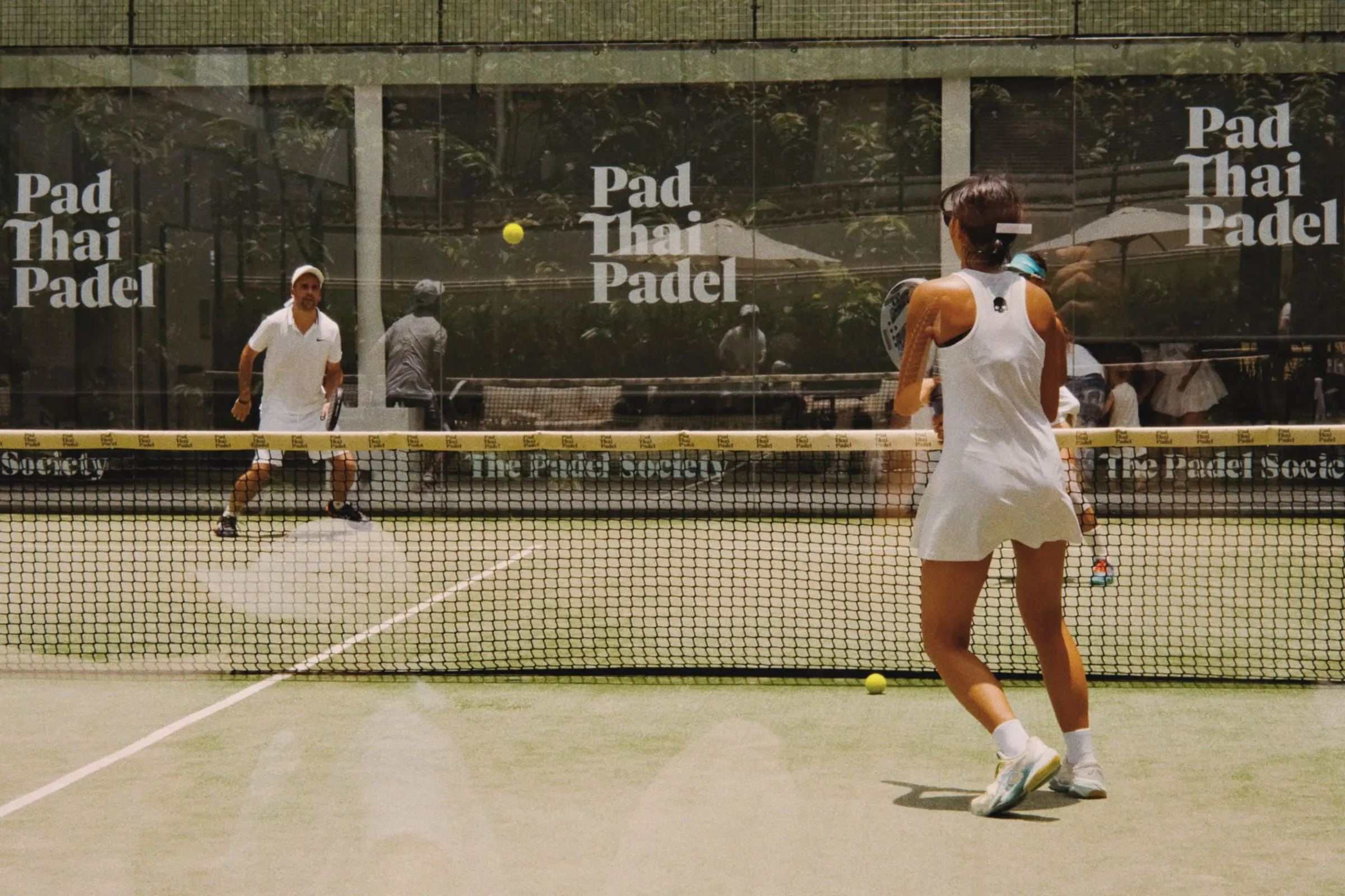 Padel players on an outdoor court in Thailand